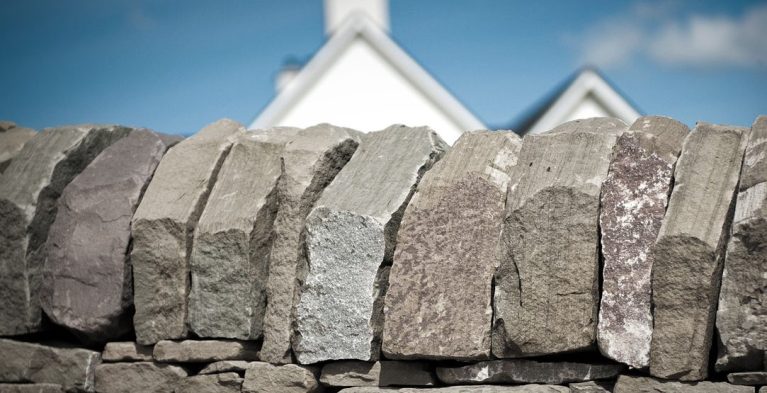 Stone Dyke Wall with House in Background