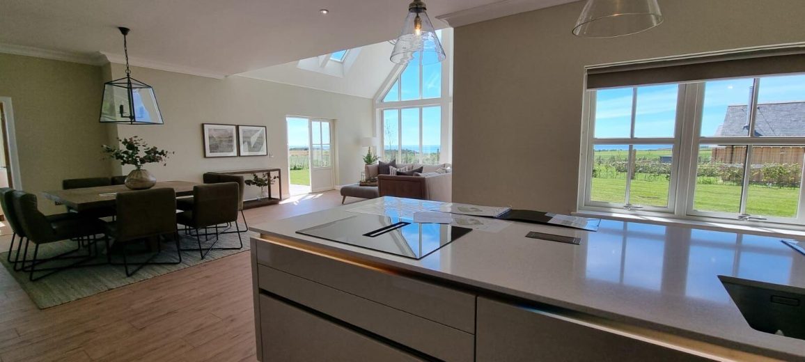 Picture of the kitchen island with view over the dining and living open space with large windows