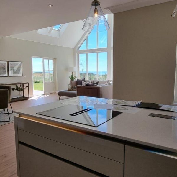 Picture of the kitchen island with view over the dining and living open space with large windows